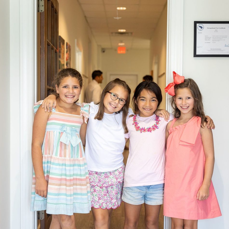 Four children stand together in a classroom doorway at Cupertino Academy