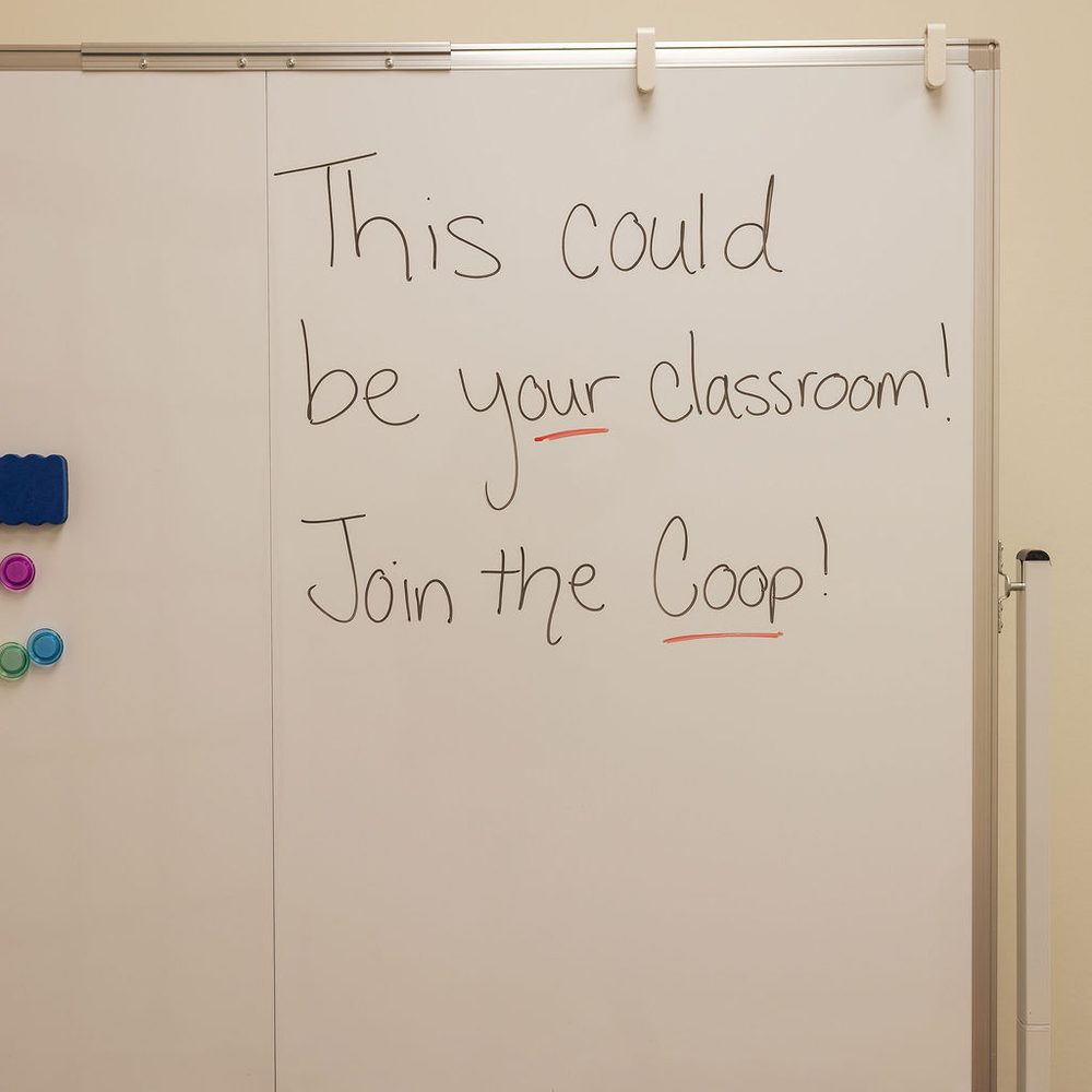 A classroom whiteboard reading: This could be your classroom! Join the Coop!