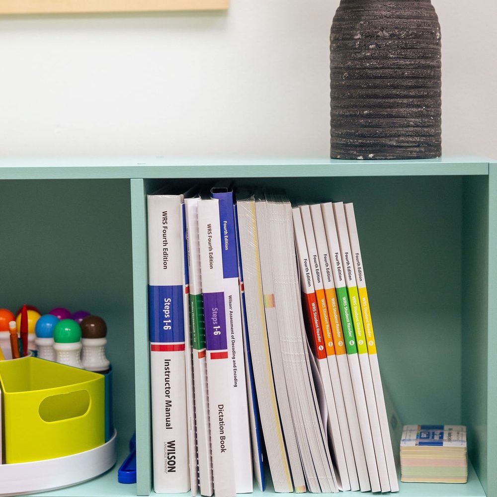 Structured Literacy manuals and lesson materials on a classroom shelf