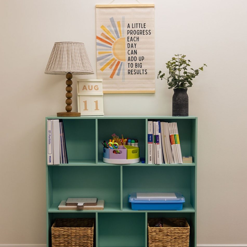 A classroom shelf with a print reading: a little progress each day can add up to big results
