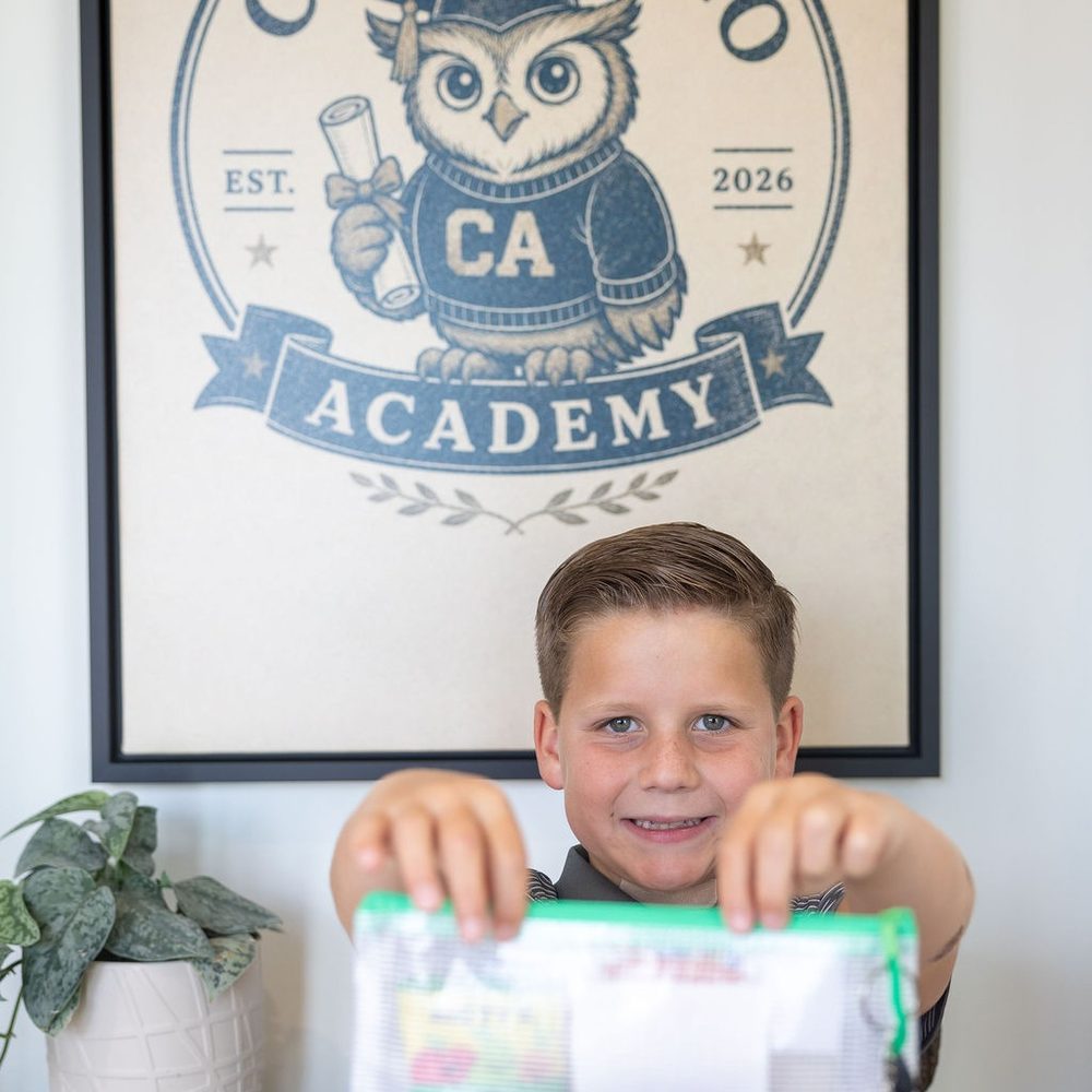A student holds up his own work folder at Cupertino Academy